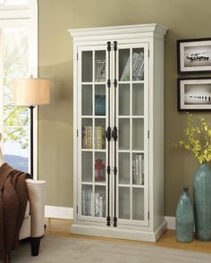 a white china cabinet with glass doors in a living room