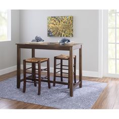 two stools sit at a table with a painting on the wall in the background