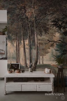 a kitchen with a painting on the wall next to a table and cabinets in front of it