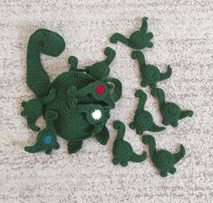 a group of green crocheted toys sitting on top of a carpet