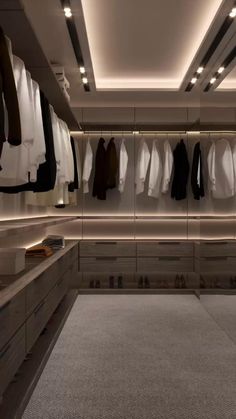 an empty walk - in closet with clothes hanging on the walls and lights on the ceiling