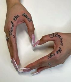 two hands with writing on their fingers and one holding the other's hand in the shape of a heart