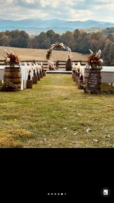 an outdoor ceremony set up with chairs and flowers on the back row, in front of mountains