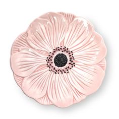 a pink flower shaped dish with black dots on the center and an intricate design in the middle