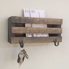 a wooden box with keys hanging from it's sides and two key hooks attached to the wall