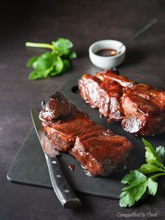 two pieces of meat sitting on top of a cutting board