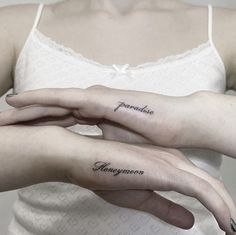 two women with matching tattoos on their hands, one holding the other's hand