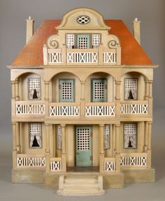 a doll house with several balconies on the front and second story, including an orange roof