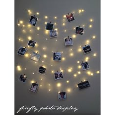 a string of lights with pictures hanging from it's sides and photos pinned to the wall