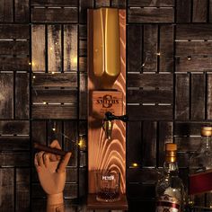 a wooden bottle opener sitting on top of a counter next to liquor bottles and glasses