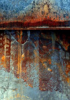 an old rusted metal surface with trees reflected in the paint and water on it