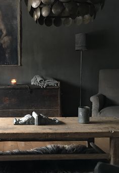 a living room filled with furniture and a painting hanging on the wall above it's coffee table