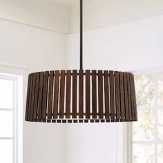 a wooden light fixture hanging from a ceiling in a room with white walls and windows