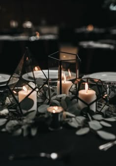 candles are lit on top of a black table cloth