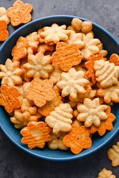 a blue bowl filled with cheesy crackers on top of a gray table