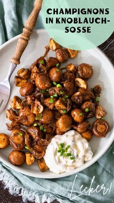 a white plate topped with fried mushrooms and sour cream on top of a blue towel