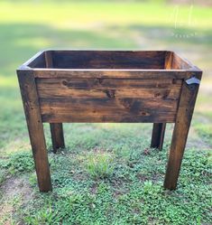 a wooden planter sitting in the grass