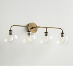 three light brass bathroom fixture with clear glass globes