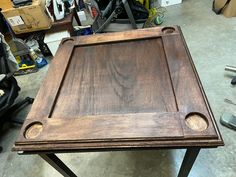 a wooden table sitting on top of a metal frame in a room filled with tools