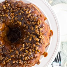 a bundt cake covered in caramel and nuts on top of a white plate