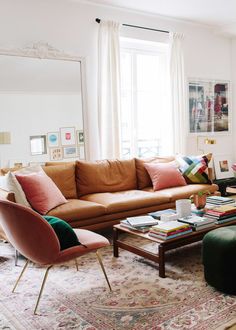 a living room filled with lots of furniture and decor on top of a carpeted floor