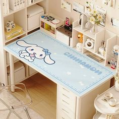 a desk with a cartoon bunny on it in the middle of a room filled with various items