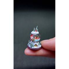 a hand holding a small christmas ornament in it's palm