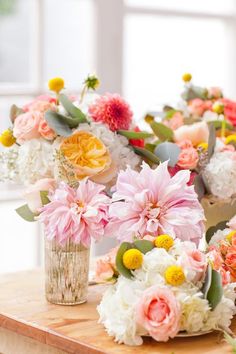 the flowers are arranged in vases on the table