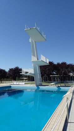 a large swimming pool with a tall white sculpture in the middle of it's side