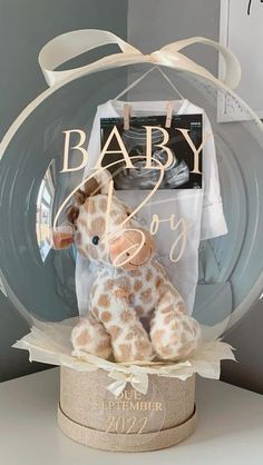 a stuffed giraffe sitting inside of a glass ball on top of a table