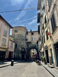 an alley way with buildings and people sitting at tables