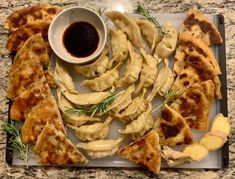 Triangularly cut slices of scallion pancakes, potsticker dumplings, dipping sauce bowl, and sliced ginger with springs of rosemary on a board Dumpling Platter, Potsticker Dumplings, Chacuterie Board, Charcuterie Ideas, Platter Board, Scallion Pancakes, Christmas Dinner Party, New Years Party, Christmas Dinner