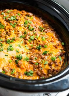 a crock pot filled with ground beef and cheese