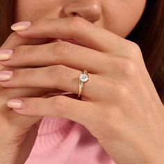 a close up of a person wearing a gold ring with a diamond on the middle