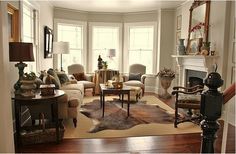 a living room filled with furniture and a fire place in the middle of a room