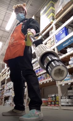 a man in an orange safety vest is using a grinder at a grocery store