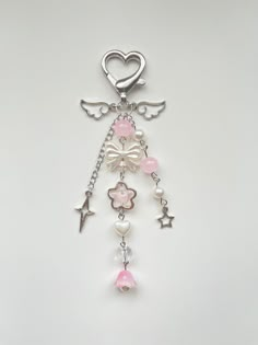 a key chain with an angel charm hanging from it's side on a white surface