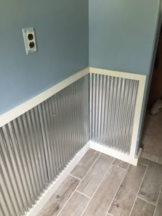 a bathroom with blue walls and white trim on the shower wall, tile flooring