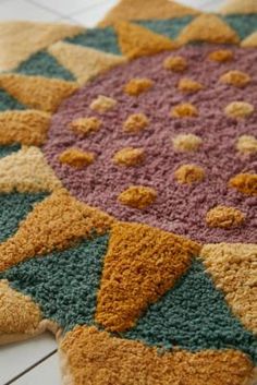 a multicolored rug on the floor is made from carpeting material that looks like an ornament