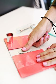 a woman is cutting out some pink paper