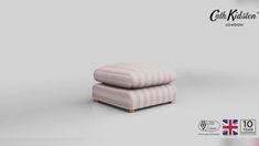 a pink and white striped ottoman sitting on top of a table next to a flag