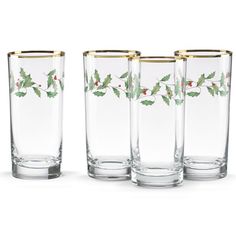 four glasses with holly designs on them are lined up in a row and one is empty