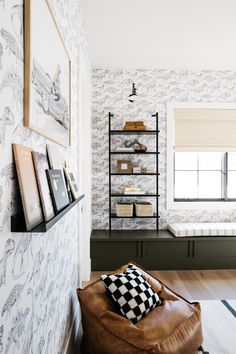 a living room with a leather chair and bookshelf next to the window in front of it