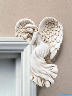 an angel figurine hanging on the side of a wall