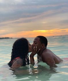 a man and woman are kissing in the water