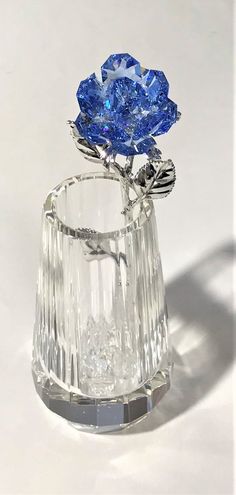 a glass vase with a blue flower in it