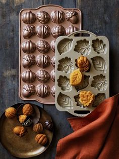 two trays filled with different types of pastries on top of a wooden table