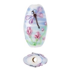 a glass clock with pink flowers and dragonflies on it's face next to a white background