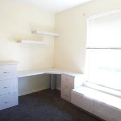 an empty room with some shelves and drawers