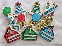 decorated birthday cookies with candles and balloons on a white cloth background, ready to be eaten